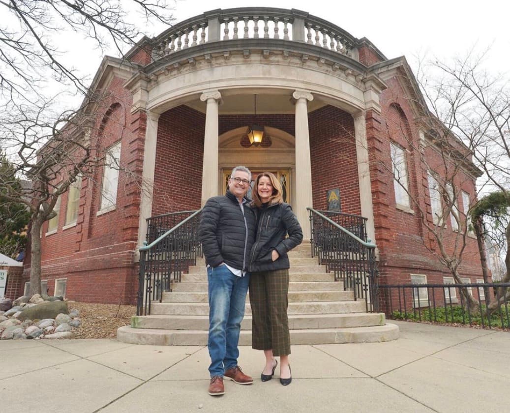 John and Shannon, owners of The Library Historic Hotel, standing on the front steps of the restored 1904 Carnegie library in St. Joseph, Michigan